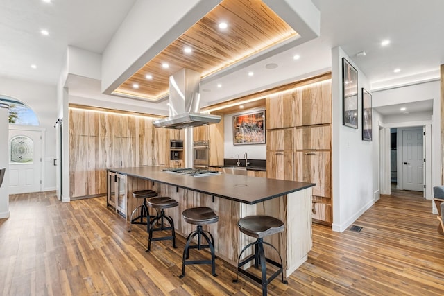 14 Buffalo Hill Cir, Kalispell, MT 59901 - kitchen with dark countertops, stainless steel appliances, island range hood, a sink, and a spacious island