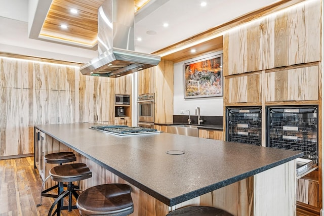 14 Buffalo Hill Cir, Kalispell, MT 59901 - kitchen featuring appliances with stainless steel finishes, wine cooler, dark countertops, island exhaust hood, and recessed lighting