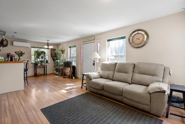 30580 Cayuse Ln, Bigfork, MT 59911 - living area featuring a wall unit AC, light wood-style floors, and a chandelier