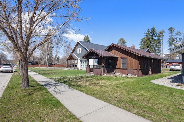 916 2nd St E, Whitefish, MT 59937 - view of side of home with a yard, a chimney, and a metal roof