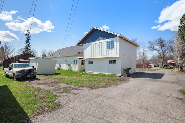 916 2nd St E, Whitefish, MT 59937 - rear view of house with a yard, driveway, and board and batten siding