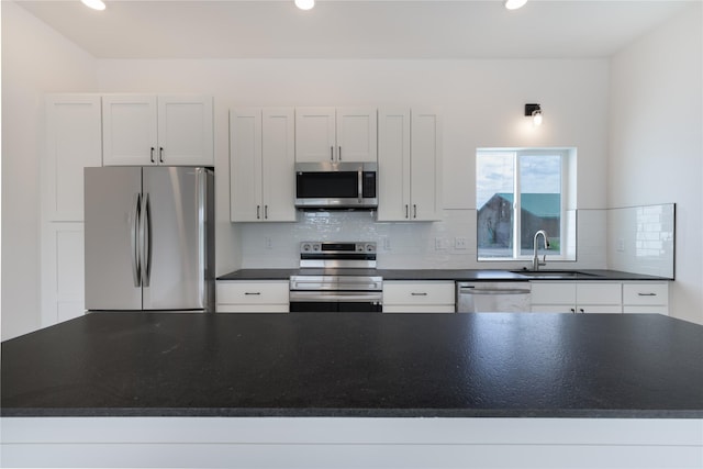 209 Pearl St, Ennis, MT 59729 - kitchen featuring appliances with stainless steel finishes, a sink, dark countertops, decorative backsplash, and recessed lighting