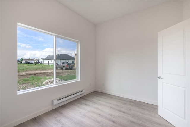 209 Pearl St, Ennis, MT 59729 - spare room featuring a baseboard heating unit, light wood-style floors, and baseboards