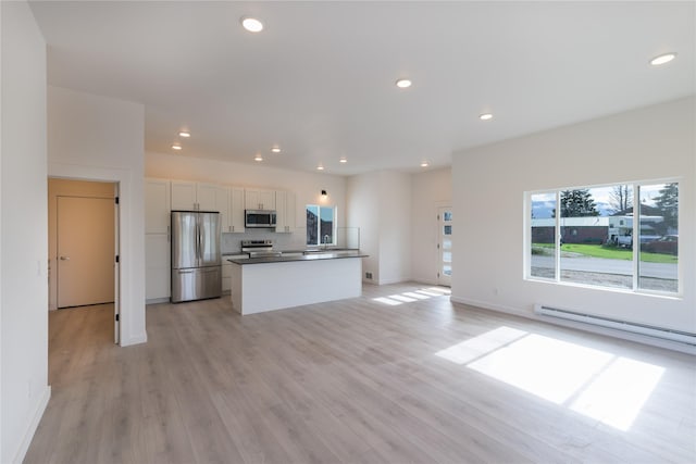 209 Pearl St, Ennis, MT 59729 - kitchen featuring stainless steel appliances, white cabinetry, a center island, open floor plan, and a baseboard heating unit