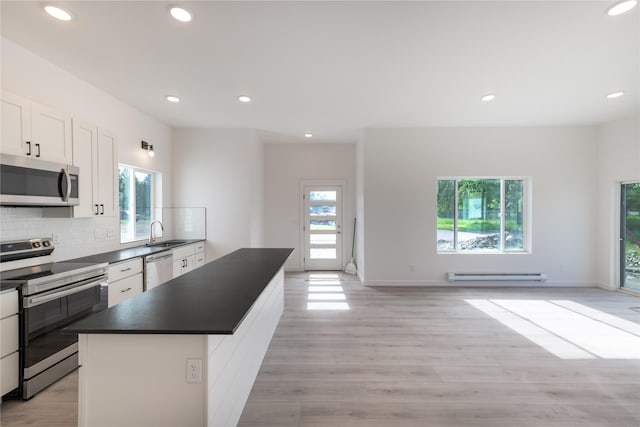209 Pearl St, Ennis, MT 59729 - kitchen featuring stainless steel appliances, baseboard heating, a sink, dark countertops, and light wood-type flooring