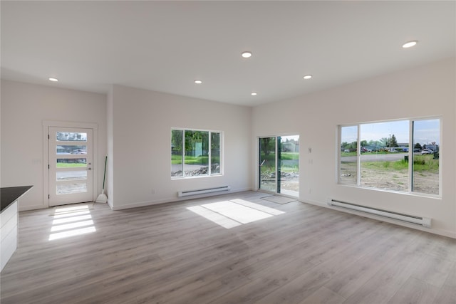 209 Pearl St, Ennis, MT 59729 - unfurnished living room featuring a baseboard radiator, recessed lighting, light wood-type flooring, and baseboards