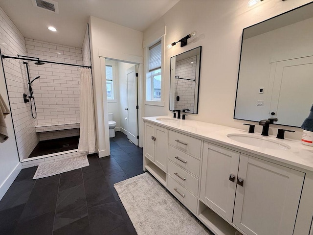 123 Owl Loop, Kalispell, MT 59901 - bathroom featuring a shower stall, a sink, double vanity, visible vents, and toilet