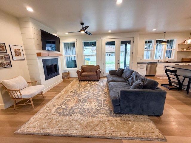 123 Owl Loop, Kalispell, MT 59901 - living room with a glass covered fireplace, french doors, ceiling fan, and light wood finished floors