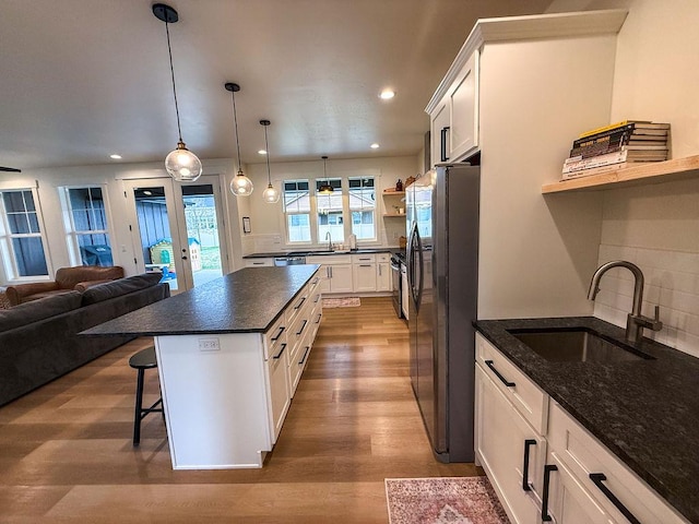 123 Owl Loop, Kalispell, MT 59901 - kitchen with wood finished floors, freestanding refrigerator, open shelves, white cabinets, and a sink