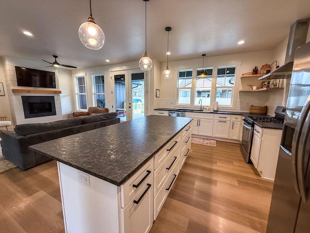 123 Owl Loop, Kalispell, MT 59901 - kitchen featuring light wood finished floors, a sink, ceiling fan, white cabinets, and appliances with stainless steel finishes
