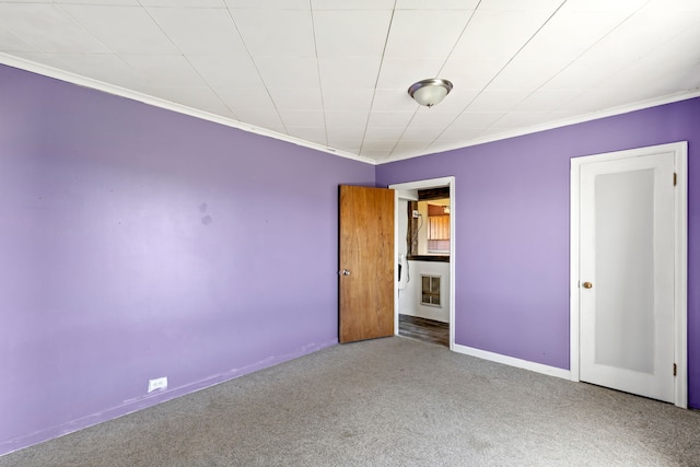 unfurnished bedroom with baseboards, ornamental molding, and carpet floors