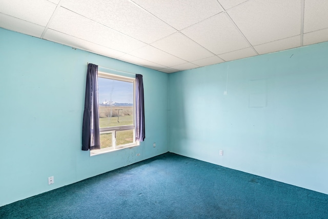 carpeted empty room with a paneled ceiling