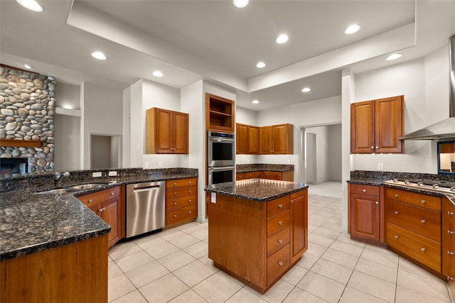 kitchen featuring recessed lighting, a sink, stainless steel appliances, light tile patterned floors, and a kitchen island