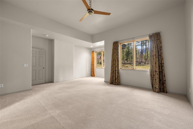 spare room with ceiling fan and light carpet