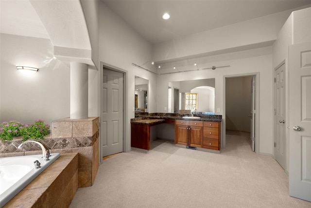bathroom with a garden tub and vanity