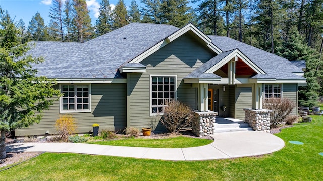 view of front facade featuring a front yard and roof with shingles