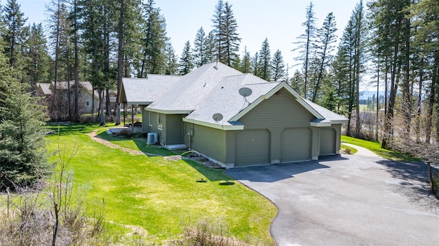 view of property exterior with cooling unit, aphalt driveway, a shingled roof, an attached garage, and a lawn