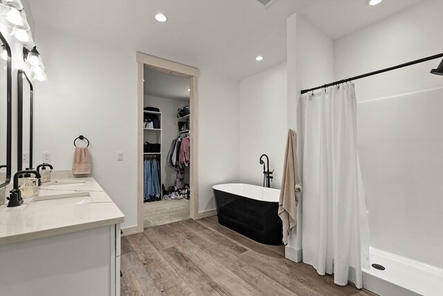 21 Bear Paw Loop, Bigfork, MT 59911 - full bathroom with double vanity, wood finished floors, recessed lighting, a shower with shower curtain, and a walk in closet
