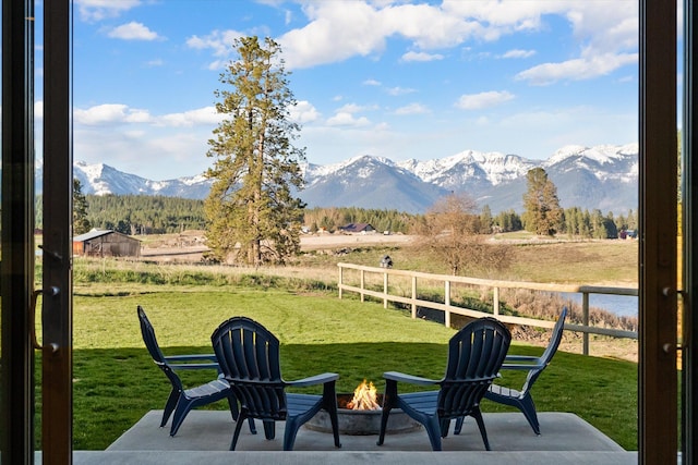 21 Bear Paw Loop, Bigfork, MT 59911 - view of yard with a mountain view, an outdoor fire pit, a view of rural / pastoral area, and a patio area