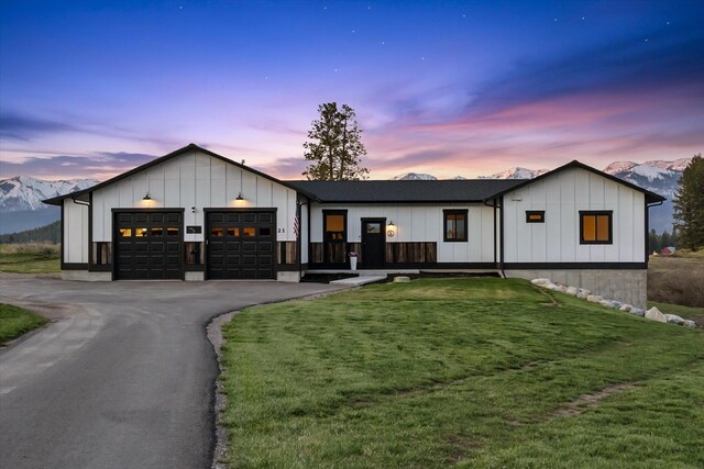 21 Bear Paw Loop, Bigfork, MT 59911 - modern inspired farmhouse featuring an attached garage, board and batten siding, a front yard, and asphalt driveway