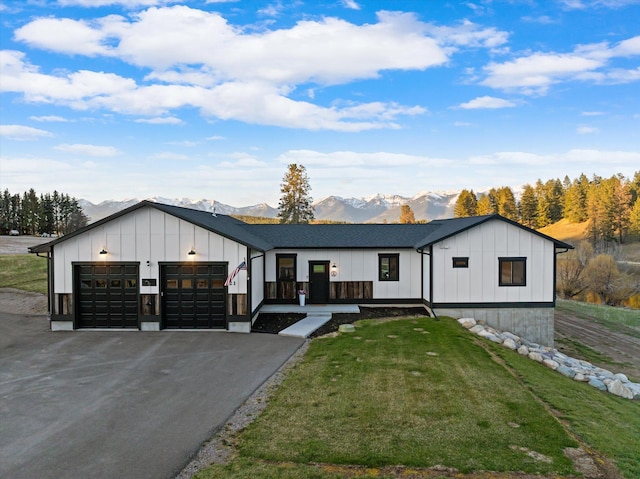 21 Bear Paw Loop, Bigfork, MT 59911 - modern farmhouse style home with board and batten siding, a mountain view, a garage, and driveway