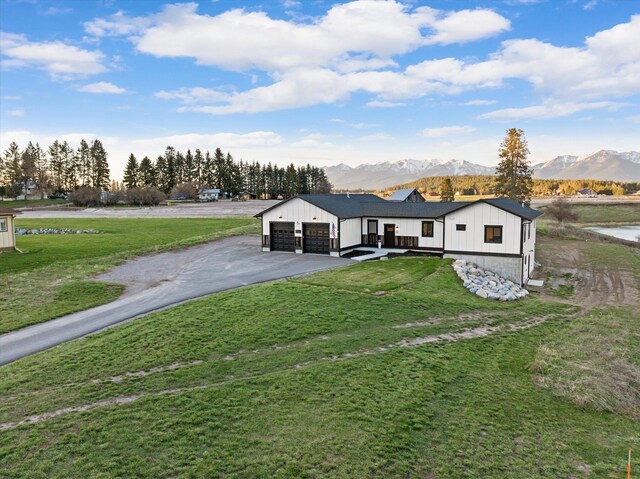 21 Bear Paw Loop, Bigfork, MT 59911 - view of front of house with a garage, a mountain view, a front yard, and driveway