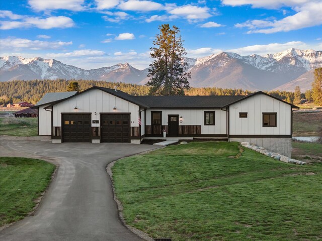 21 Bear Paw Loop, Bigfork, MT 59911 - modern inspired farmhouse with board and batten siding, an attached garage, a mountain view, and asphalt driveway