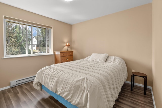 bedroom featuring baseboards, wood finished floors, and a baseboard radiator