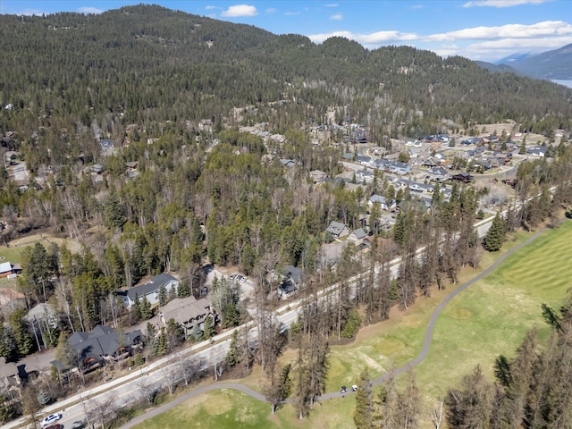 drone / aerial view with a residential view, a mountain view, golf course view, and a wooded view