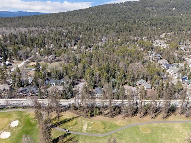 aerial view with a wooded view, a residential view, a mountain view, and view of golf course