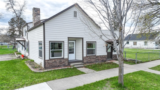648 7th Ave W, Kalispell, MT 59901 - view of property with a chimney and stone siding
