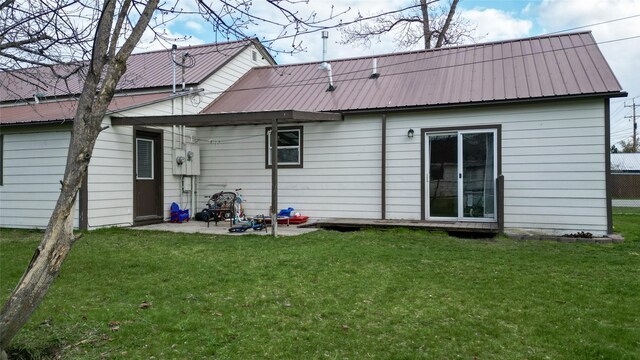 648 7th Ave W, Kalispell, MT 59901 - rear view of property with a yard, a patio area, and metal roof