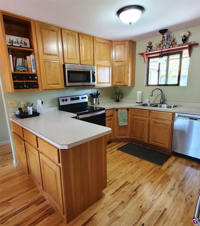 3208 Paul Ln, Missoula, MT 59803 - kitchen featuring a sink, light wood-style floors, stainless steel appliances, light countertops, and a peninsula