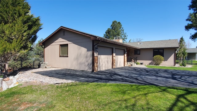 3208 Paul Ln, Missoula, MT 59803 - single story home with aphalt driveway, a chimney, an attached garage, fence, and a front lawn