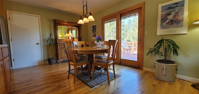 3208 Paul Ln, Missoula, MT 59803 - dining area with baseboards, a notable chandelier, and light wood-style flooring