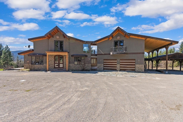 15 Copper Ridge Rd, Trout Creek, MT 59874 - view of front of property with french doors, stone siding, an attached garage, and stucco siding