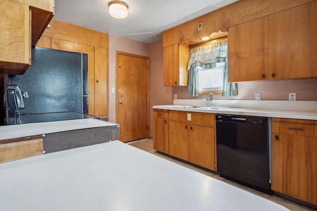 kitchen featuring black appliances, a sink, brown cabinets, and light countertops