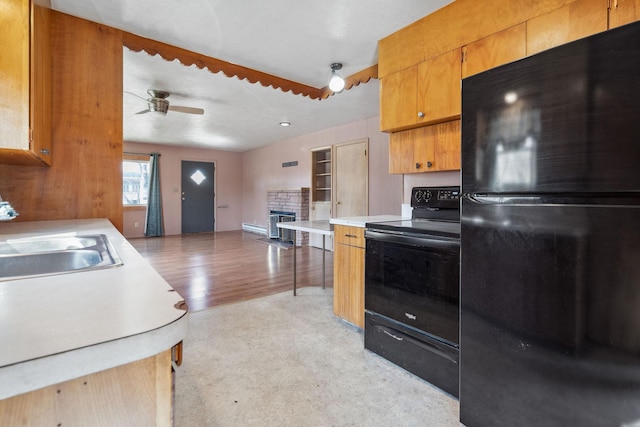 kitchen featuring a sink, a fireplace, ceiling fan, black appliances, and light countertops