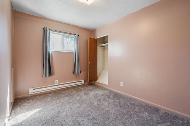 unfurnished bedroom with a baseboard heating unit, carpet floors, and baseboards