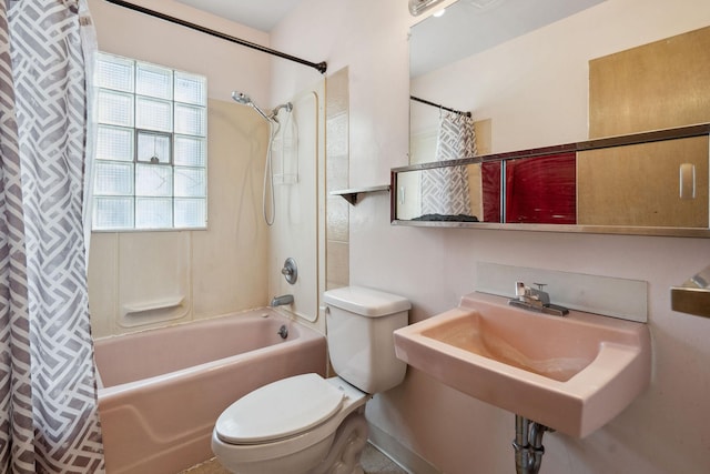 bathroom with shower / bathtub combination with curtain, toilet, and a sink