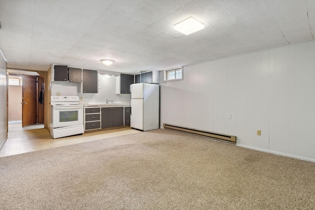 interior space with light colored carpet, baseboard heating, freestanding refrigerator, and a sink