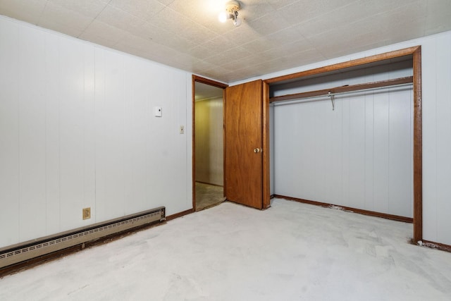 unfurnished bedroom with baseboard heating, baseboards, light colored carpet, and a closet