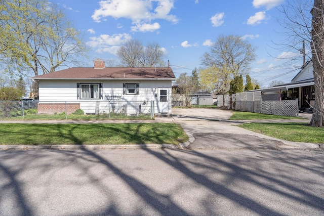 view of front of property with fence, a chimney, and a front yard