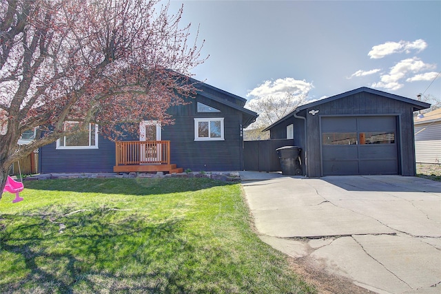 view of front of property with a front lawn, driveway, a garage, and fence
