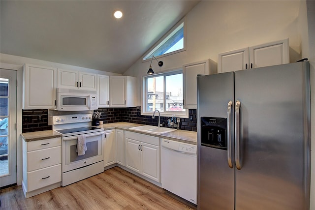 kitchen with backsplash, a sink, white cabinetry, and white appliances