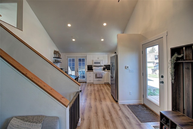 interior space featuring light wood finished floors, stairs, and a healthy amount of sunlight