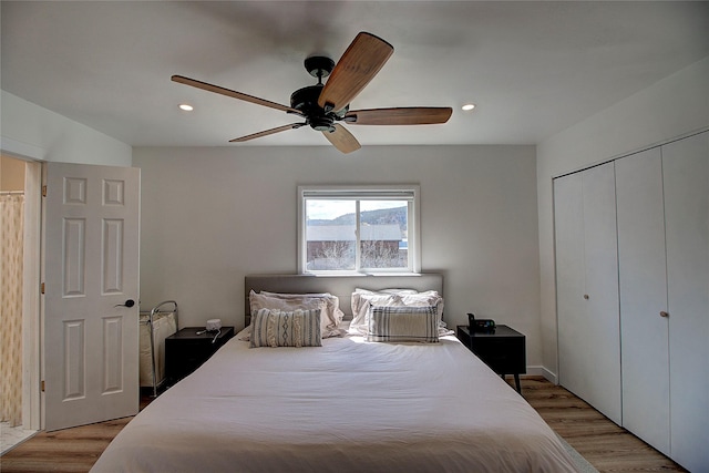 bedroom featuring light wood-type flooring, recessed lighting, a ceiling fan, and a closet