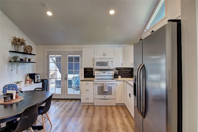kitchen featuring white appliances, light countertops, white cabinets, french doors, and lofted ceiling