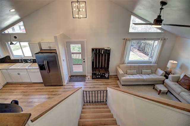 living room featuring high vaulted ceiling, a wealth of natural light, and light wood-style floors
