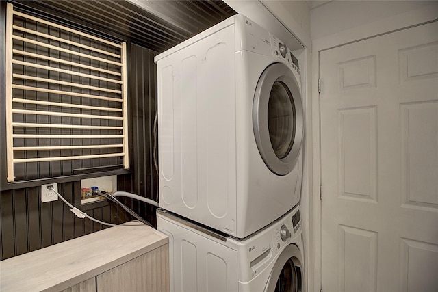 laundry room with stacked washer and clothes dryer and laundry area